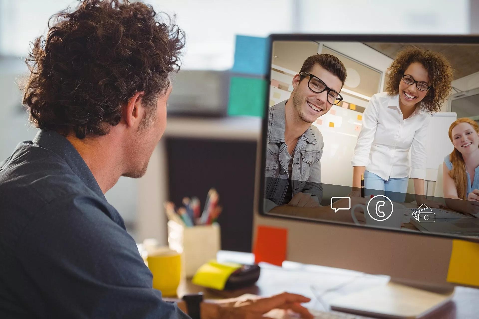 A remote employee interacts with team members through videoconferencing technology.