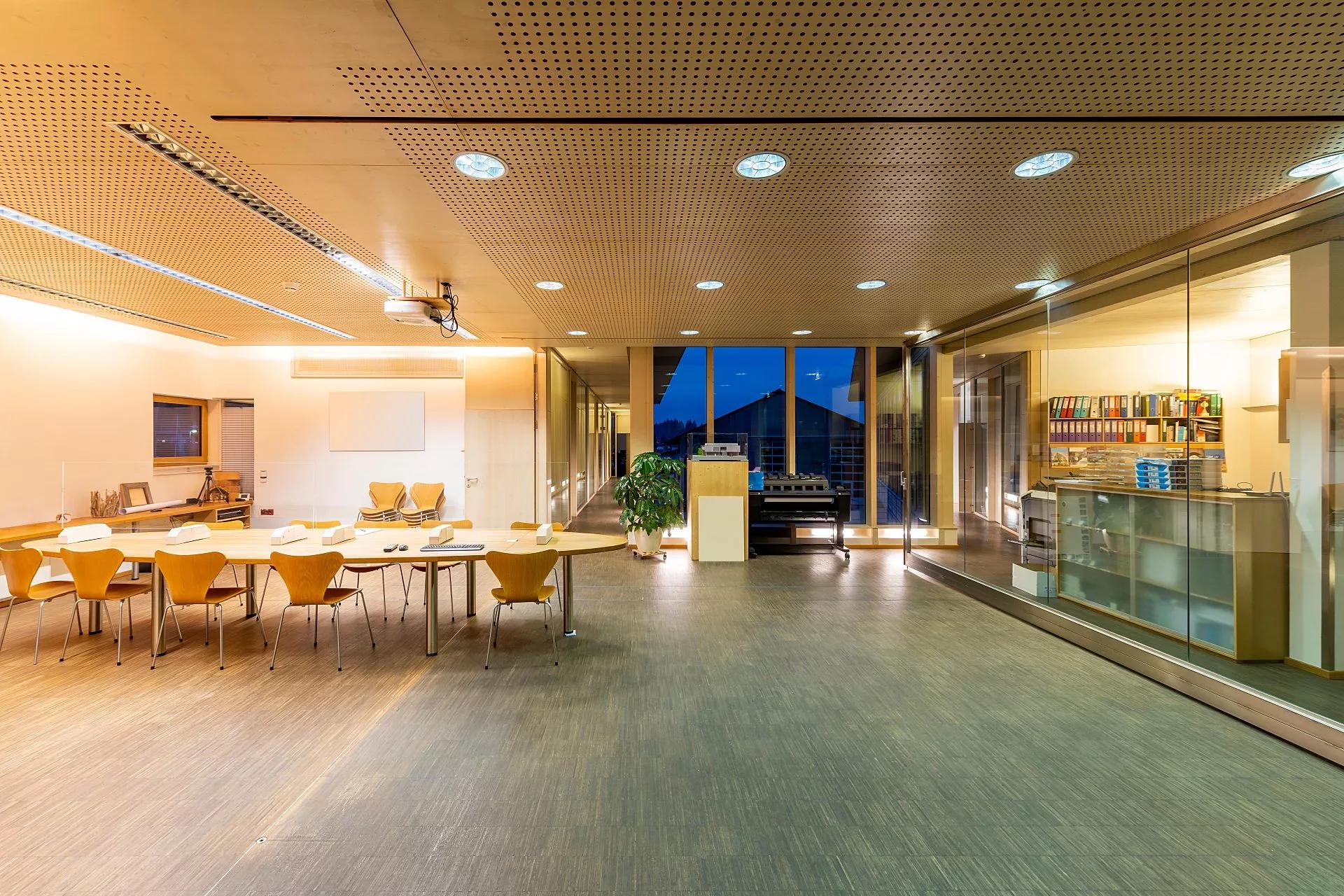 Large meeting room with acoustic ceiling and glass partition walls.