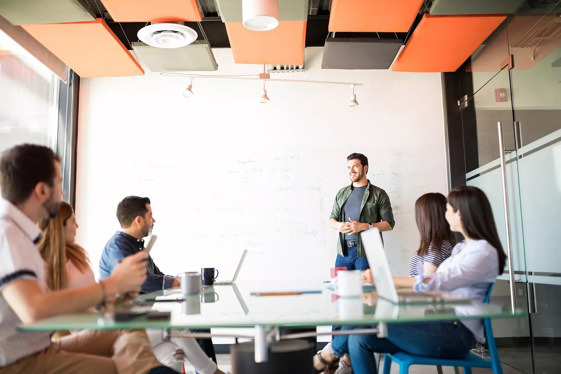 An IT team works together in a conference room to prepare their pitch.