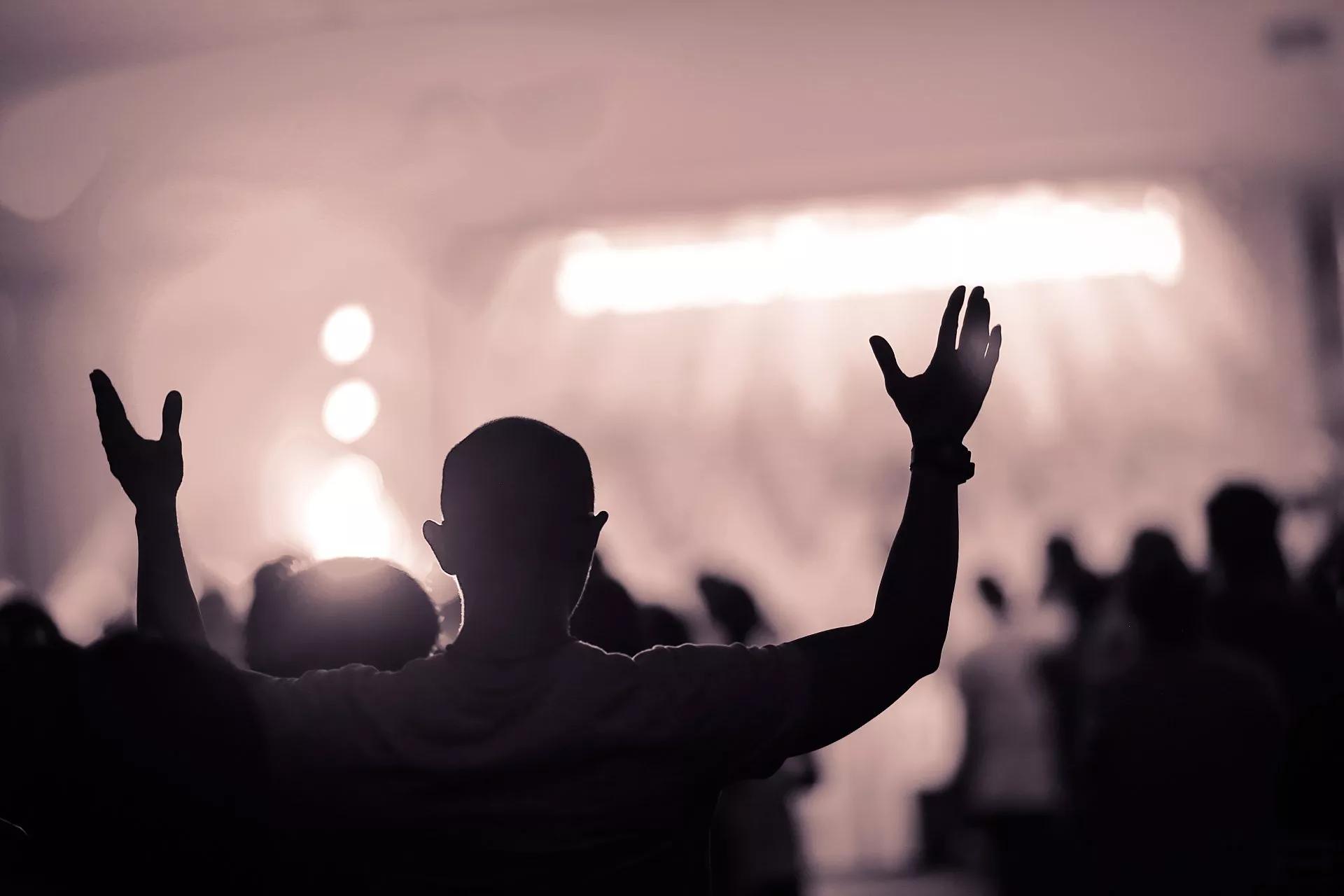 Back of churchgoer with raised hands