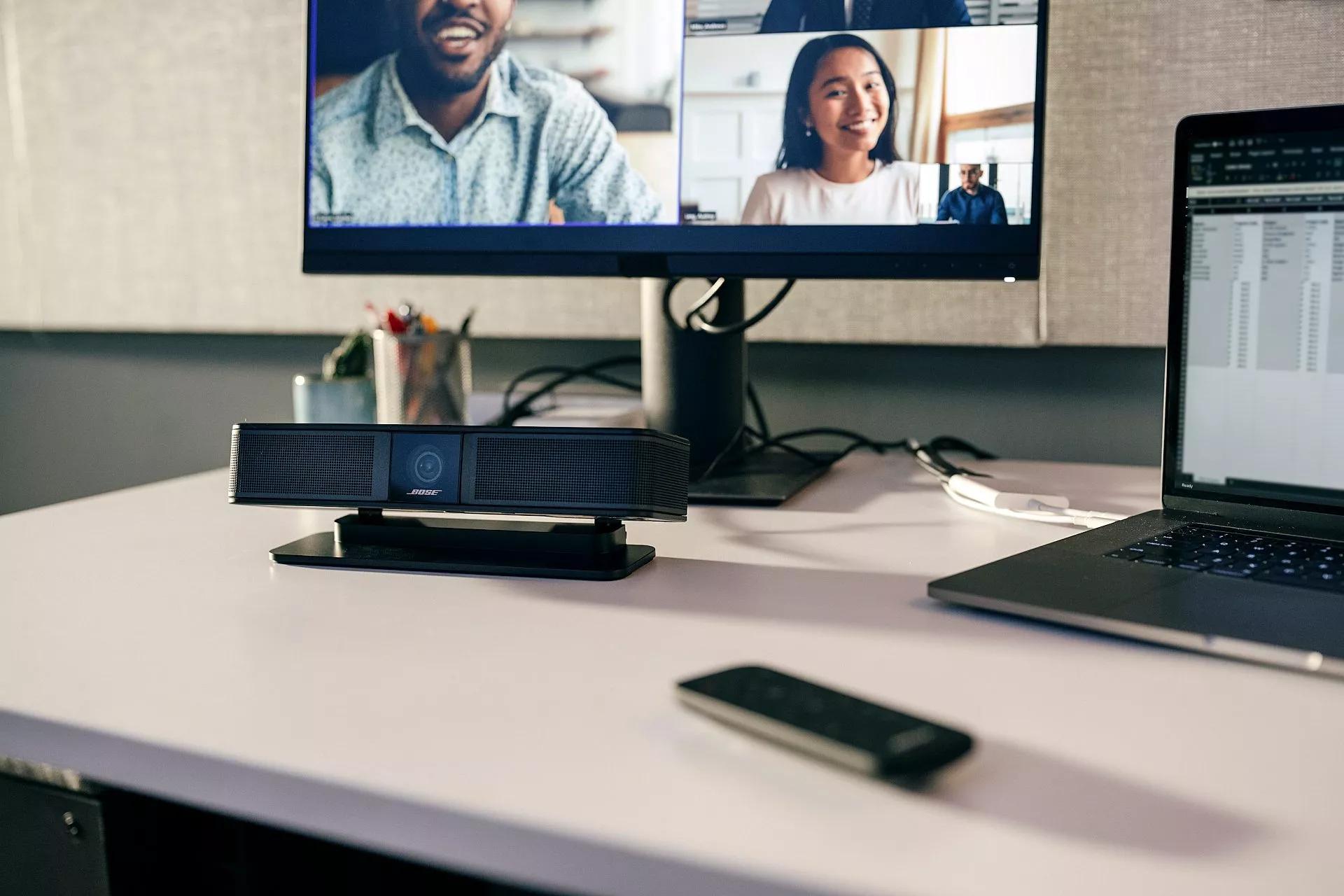 Un videobar VB-S se sitúa frente a una pantalla de vídeo con tres alumnos a distancia.