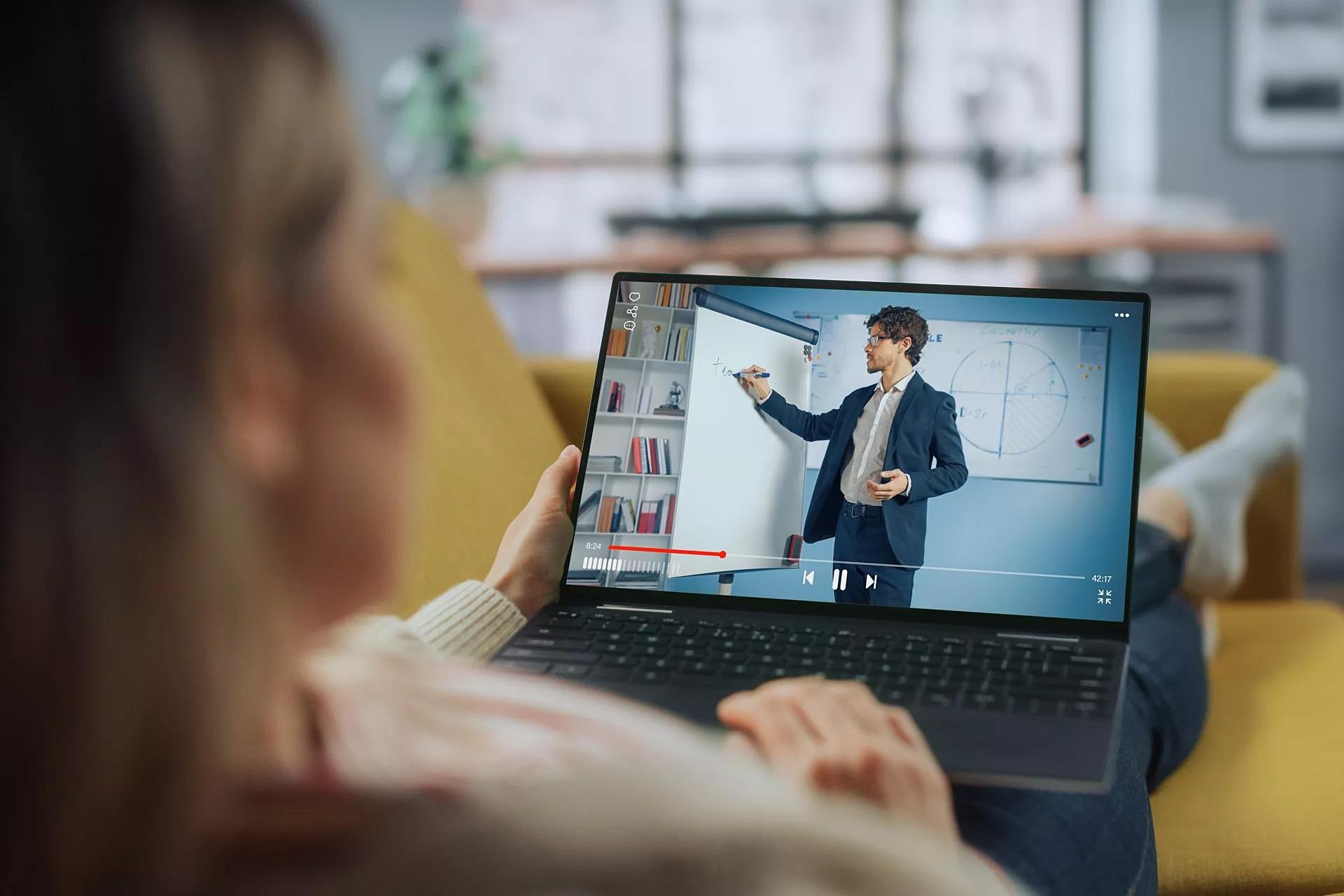 An employee watches a business presentation on their laptop.