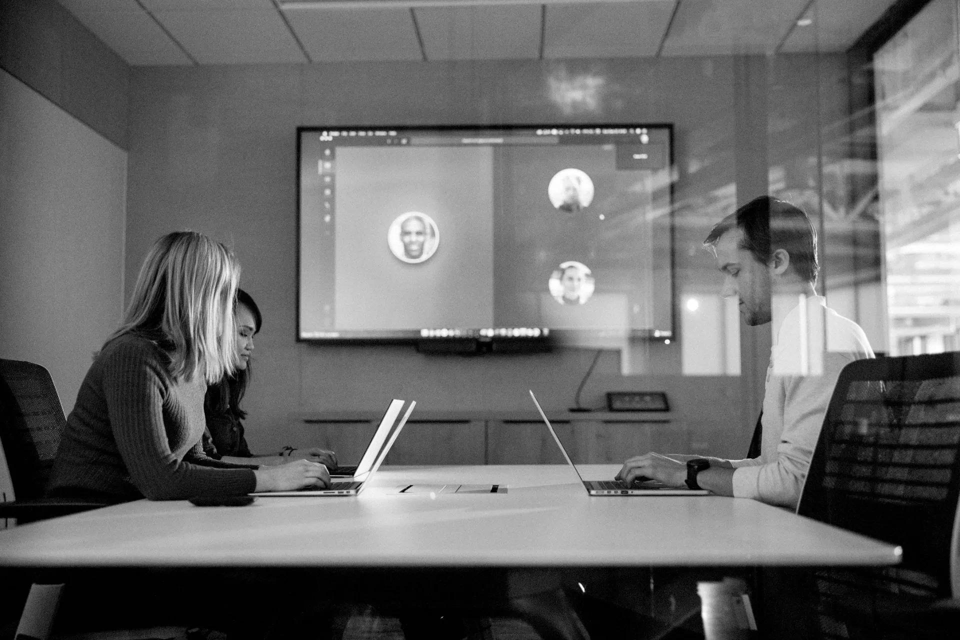 Una gran sala de conferencias con soluciones de audio en el techo y una pantalla de video