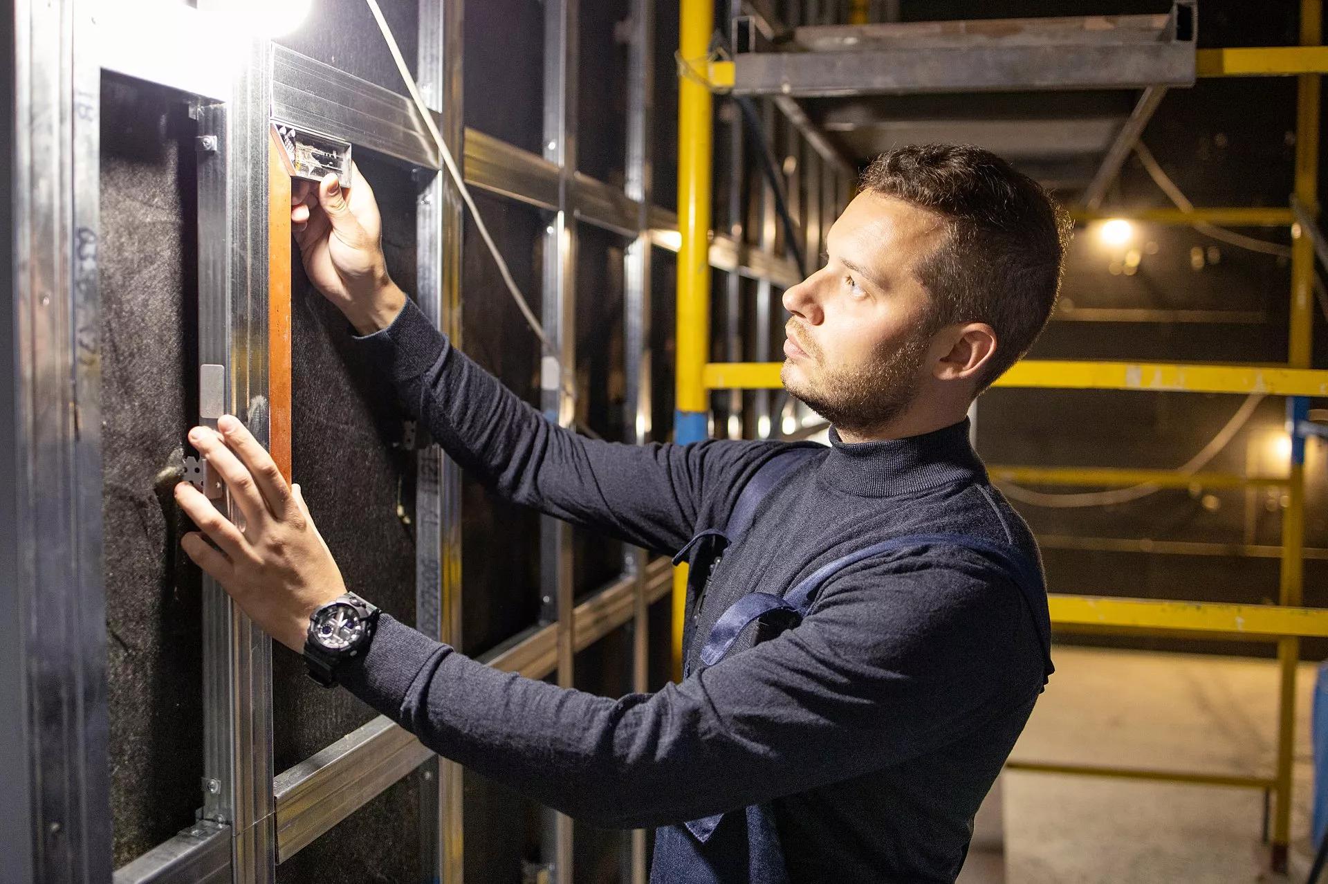 A person measuring a wall with a ruler.